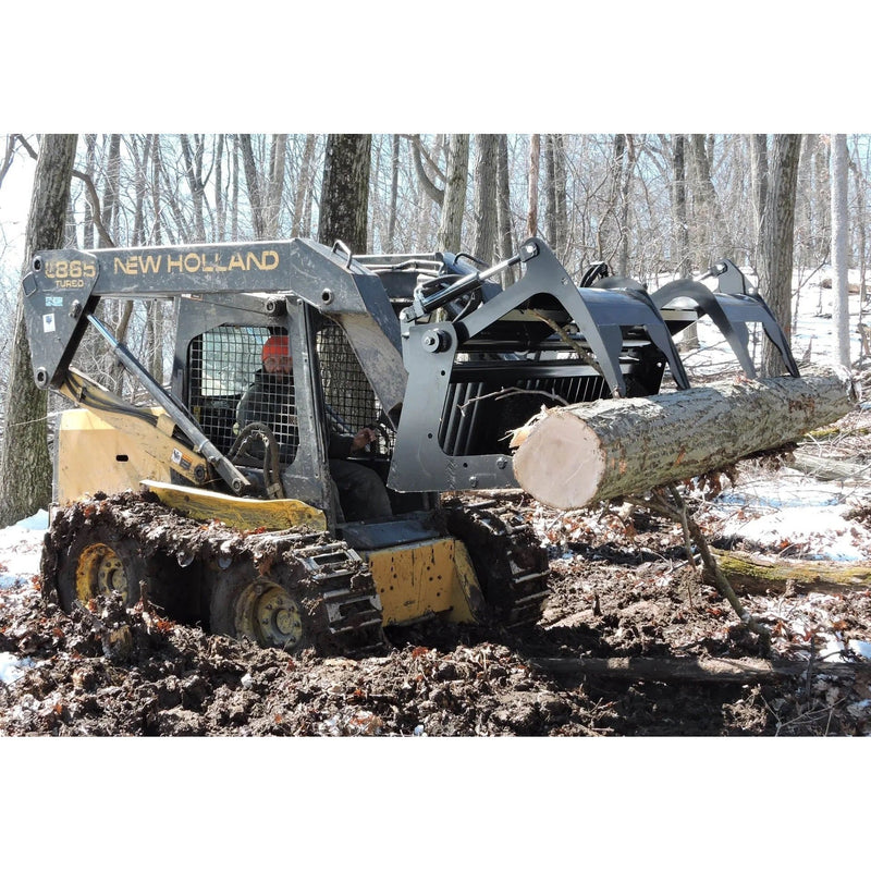Skid steer moving log in snowy forest.  